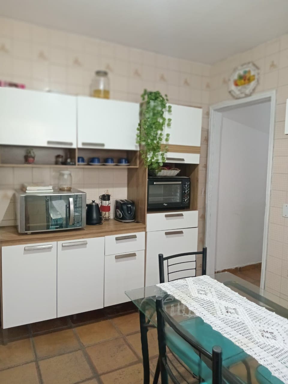 Cozinha com mesa de vidro e cadeiras turquesa