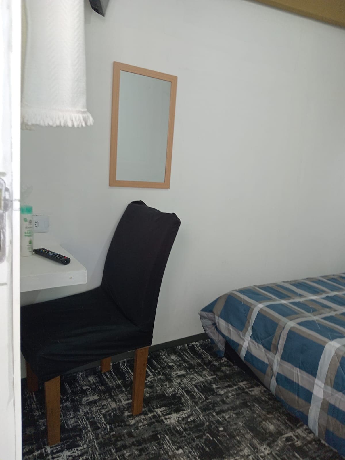 Bancada de trabalho com cadeira preta, espelho e luminária na Suíte Borboleta